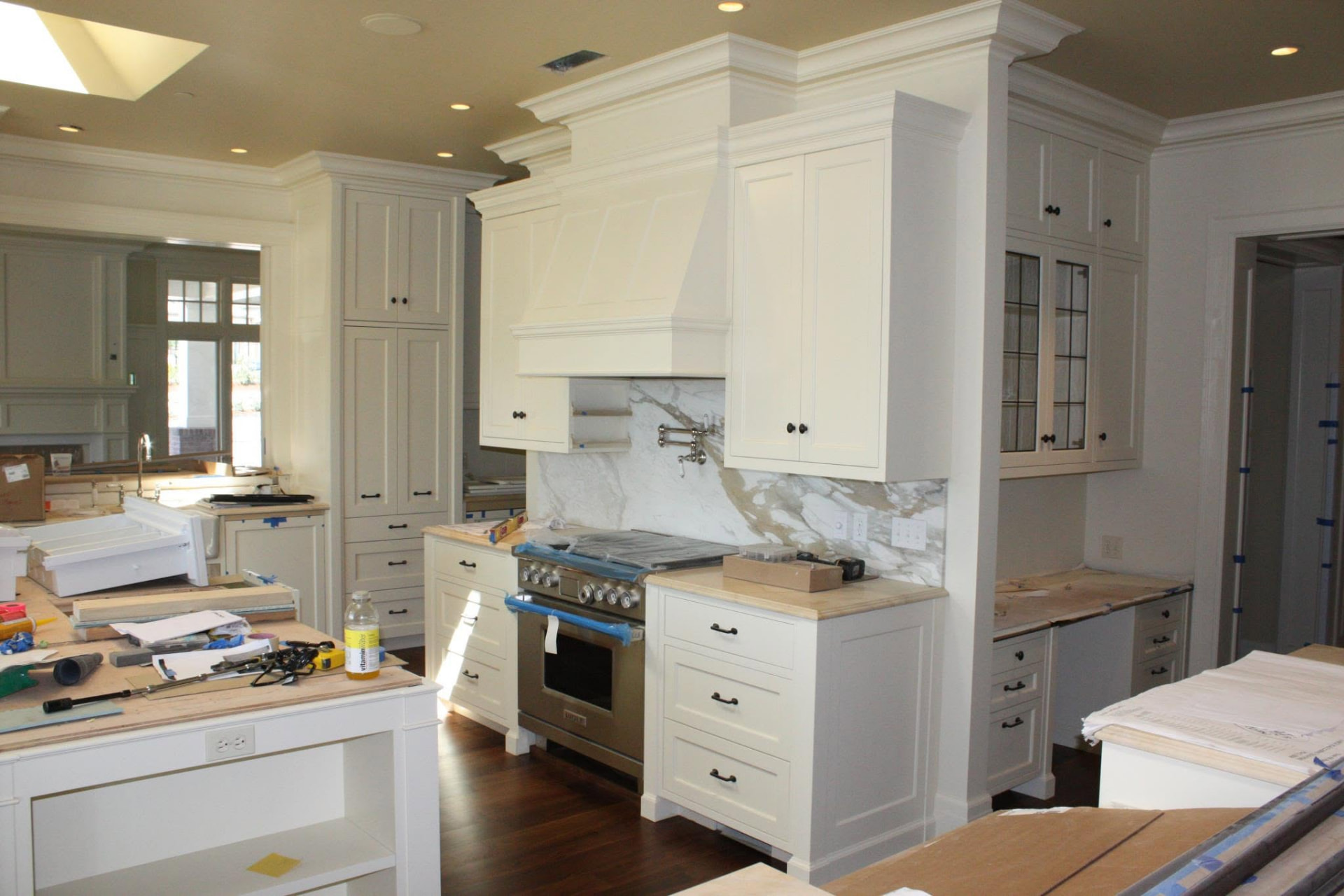 Painted inset kitchen cabinetry with custom range hood