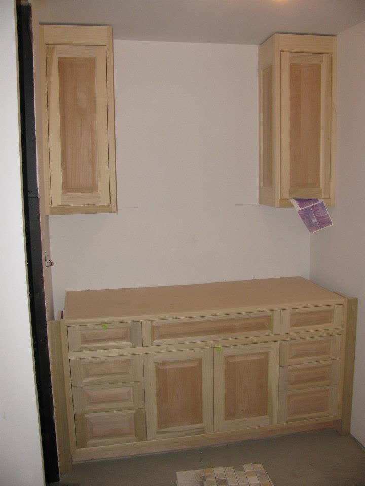 Unfinished maple vanity and wall cabinets during installation